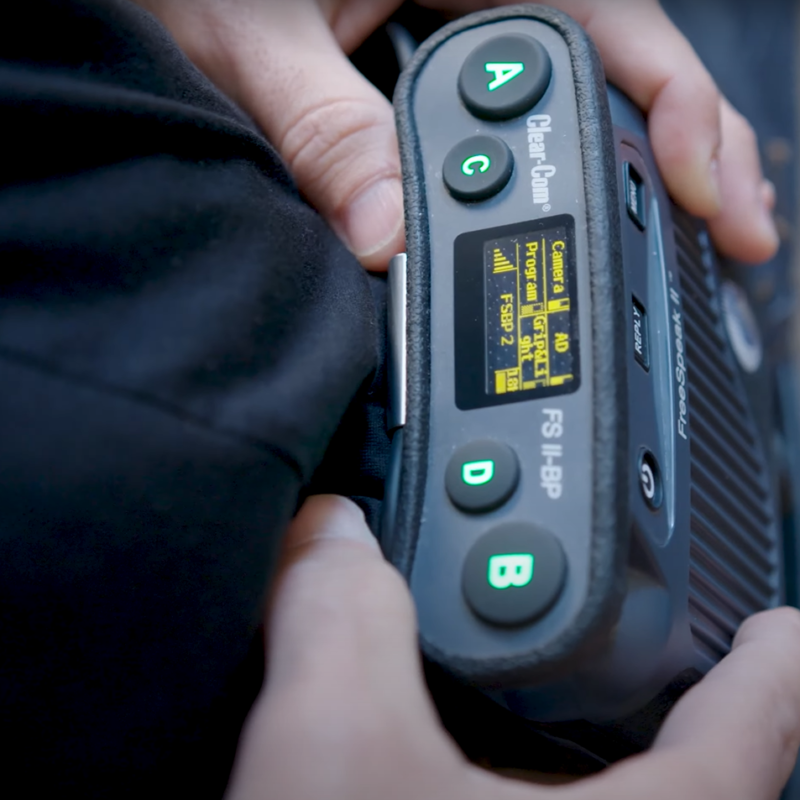 Someone holding a Clear-Com Freespeak II beltpack
